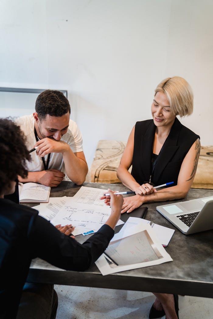 Servicios Group of professionals engaged in a collaborative meeting, planning strategies around a table in office setting.