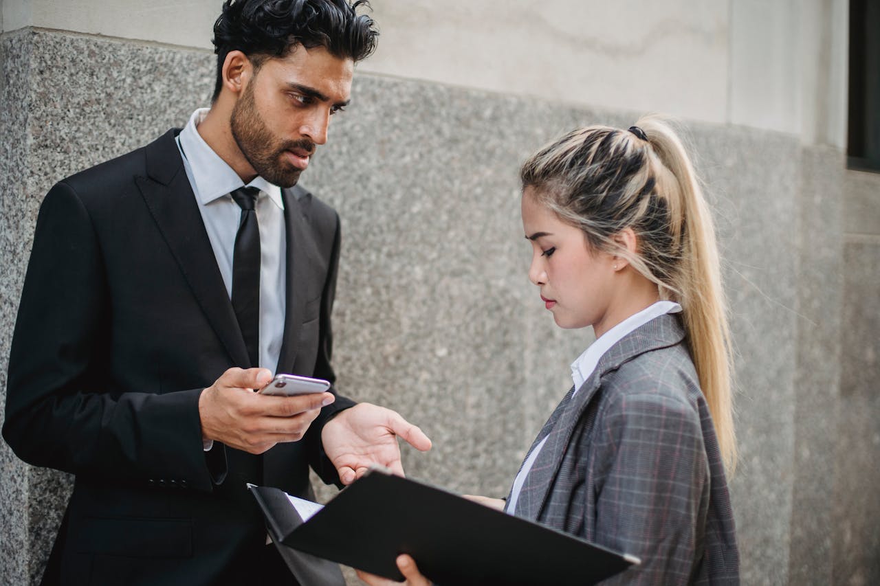 Two business professionals engaging in a serious conversation outside a building.